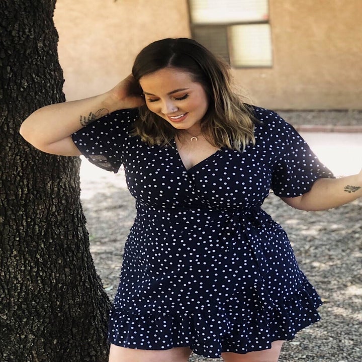 reviewer wearing the polka dot dress in navy blue