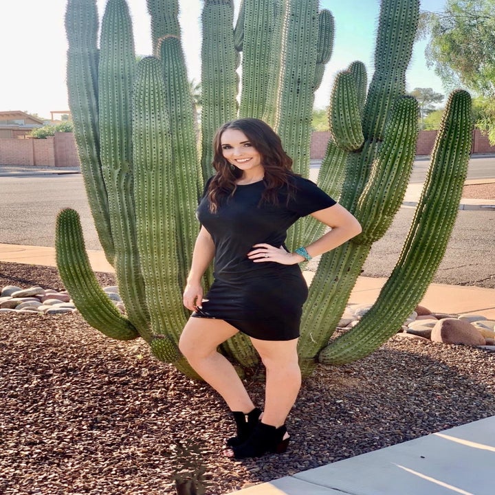 reviewer wearing a black dress while standing in front of a cactus