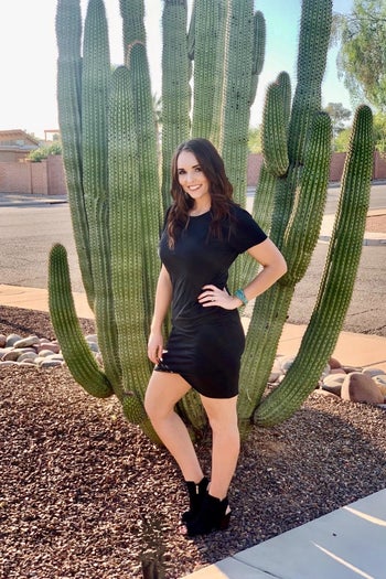 reviewer wearing a black dress while standing in front of a cactus