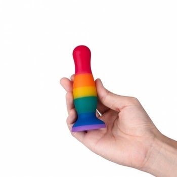 Model holding rainbow stripe silicone butt plug