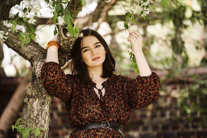 An image of the author posing under a tree