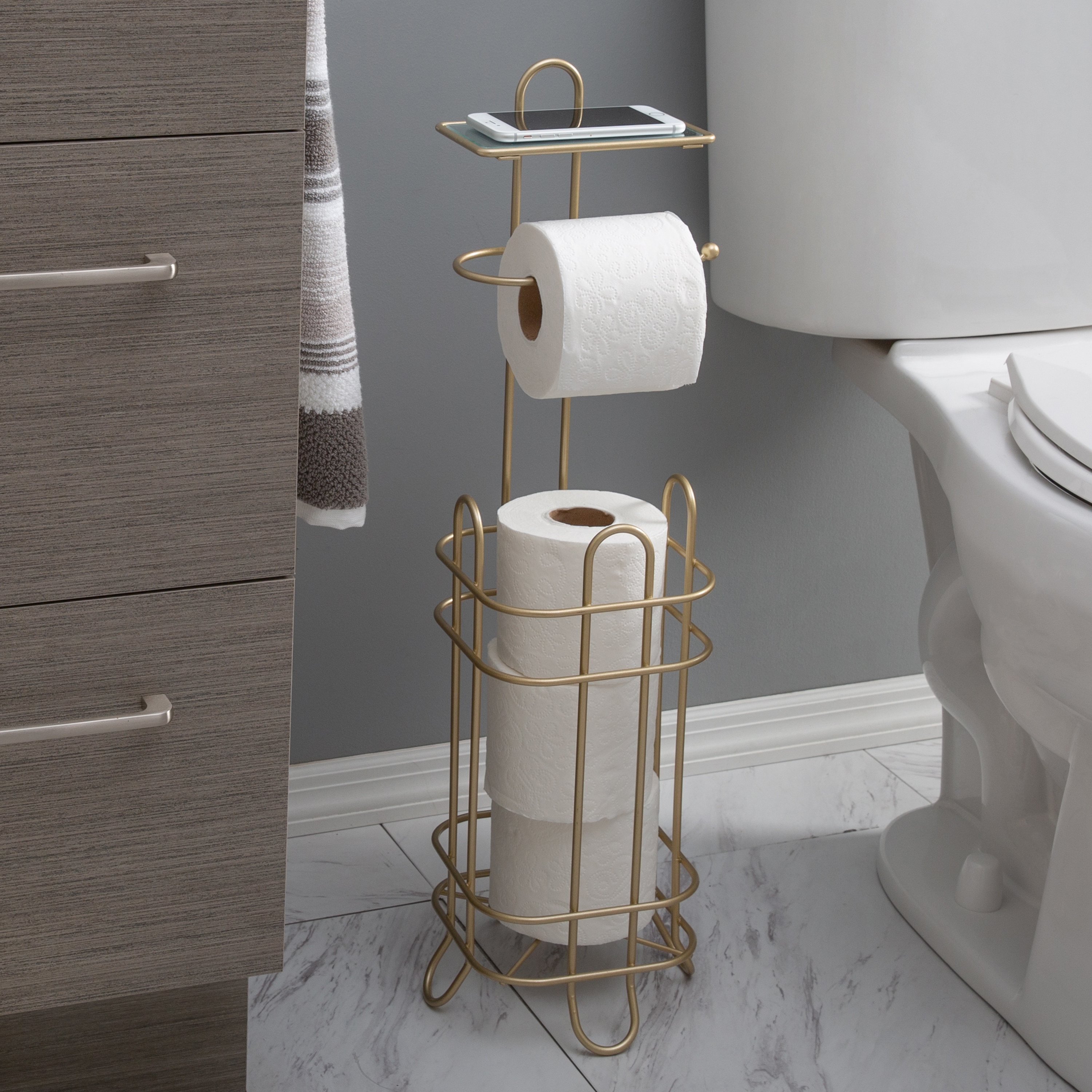a gold toilet paper roll holder dispenser in a bathroom
