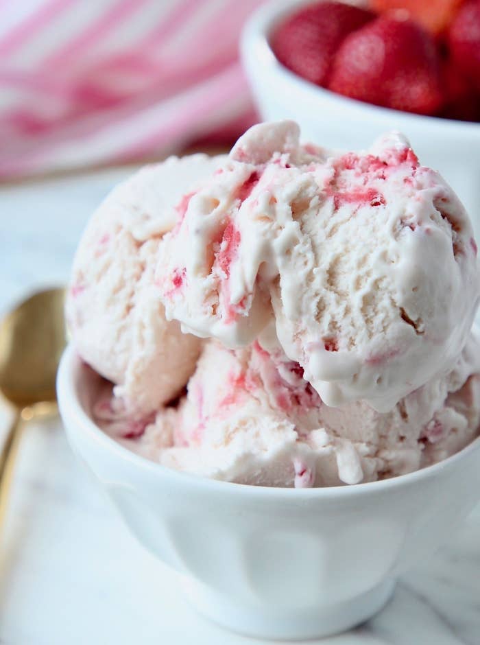 scoops of strawberry ice cream in white bowl