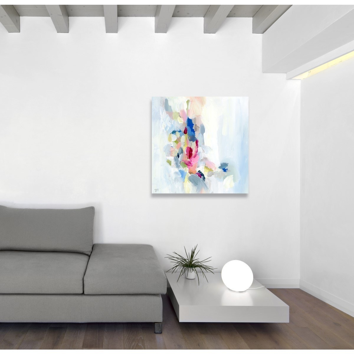 abstract painting hung above a grey couch