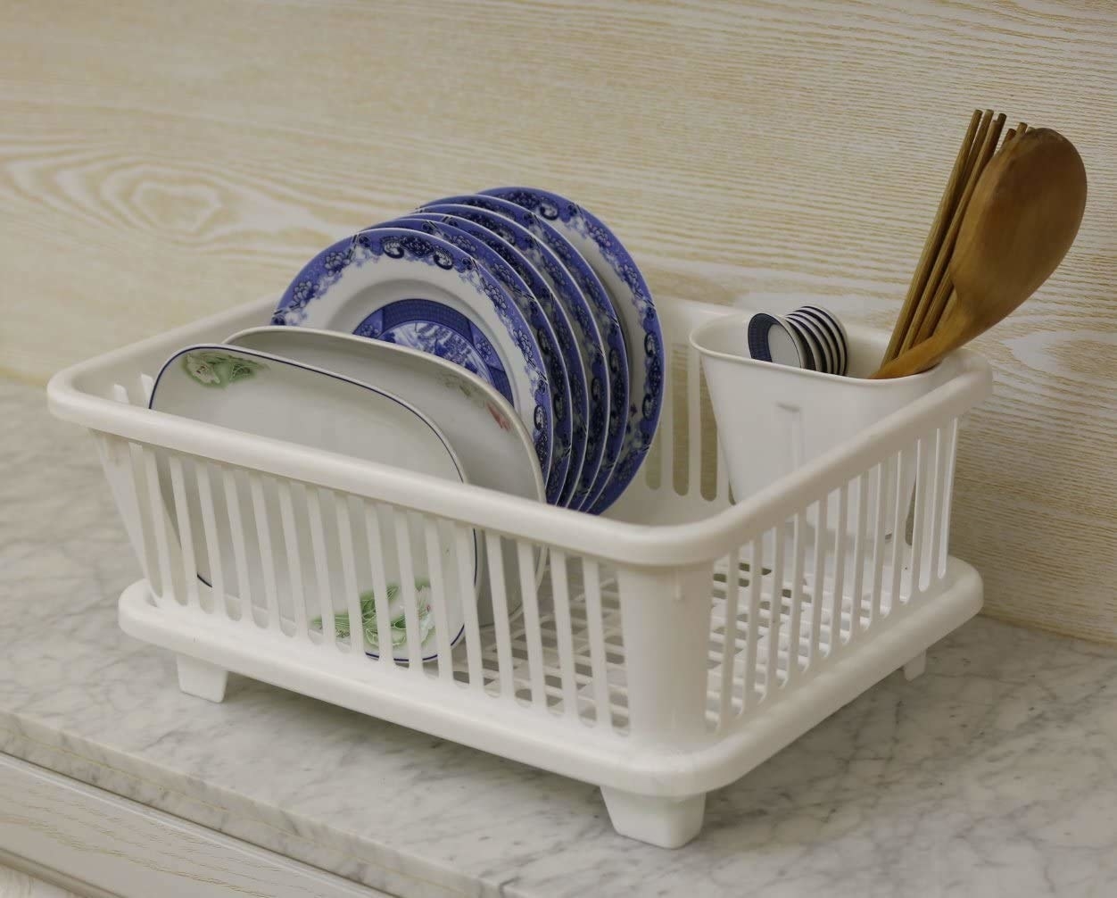 A white dish drying rack with plates and other utensils in it 