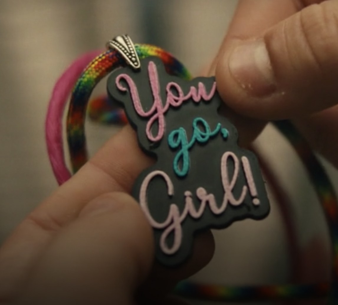 A necklace with the phrase &quot;You Go Girl&quot; in pink and blue plastic.