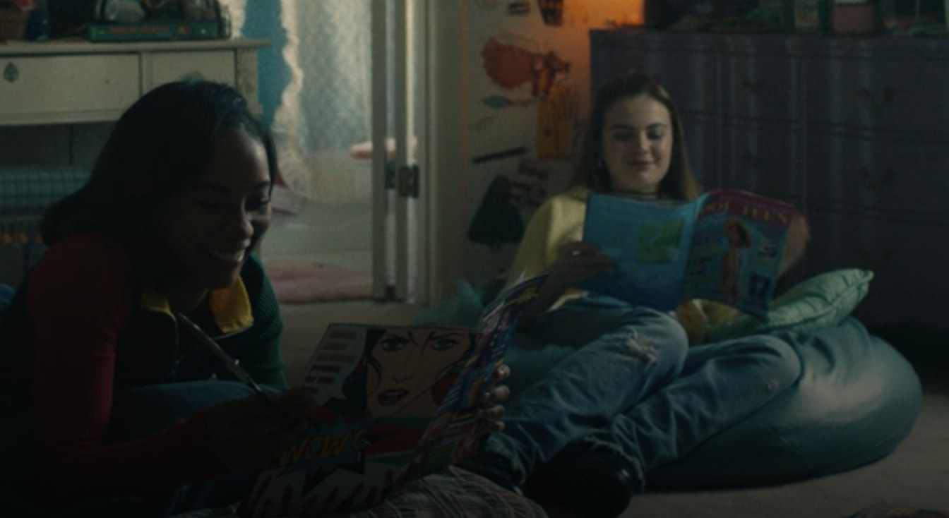 Two girls sitting on the floor in beanbag chairs reading magazines.