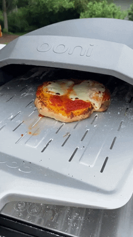 removing the pizza from the oven with a peel