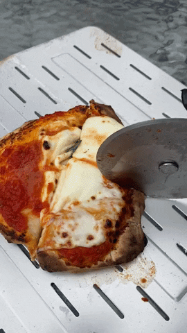 cutting the pizza with the pizza cutter