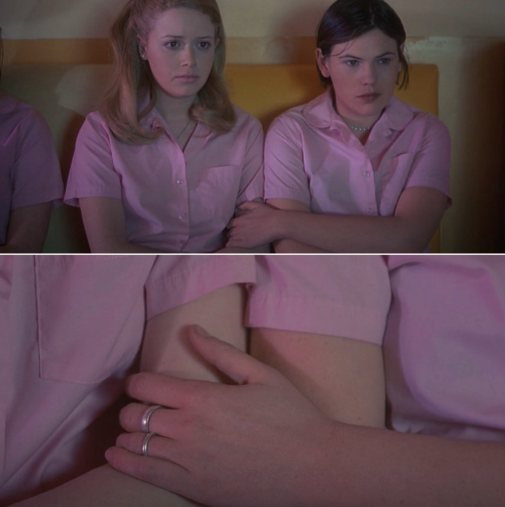 两个女人坐在对方,亲切地把她的手放在另一个女人# x27;年代的手臂