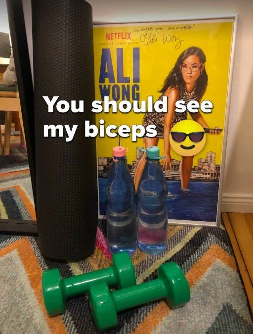 Two dumbbells and two water bottles sitting next to a yoga mat. Text on photo reads, &quot;You should see my biceps&quot;