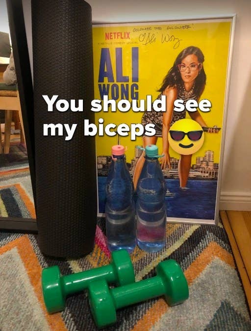 Two dumbbells and two water bottles sitting next to a yoga mat. Text on photo reads, "You should see my biceps"