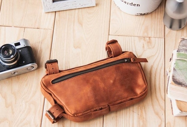 a leather saddle bag with three looped buckles you can attach to a bike 