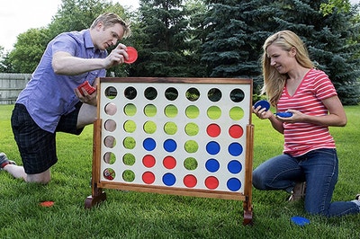 people playing a giant 4 Connect game in a backyard