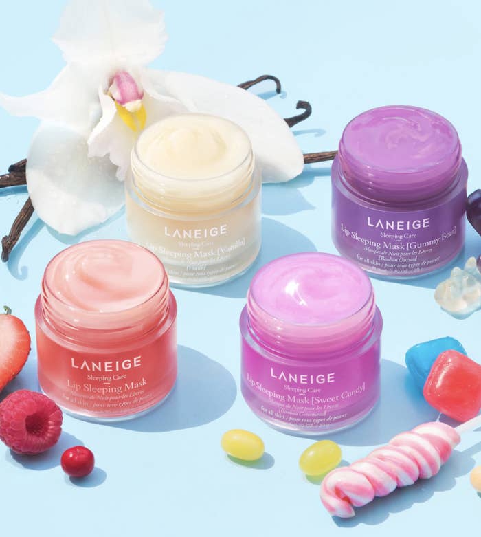 four of the tubs of lip balm surrounded with fruit and other props