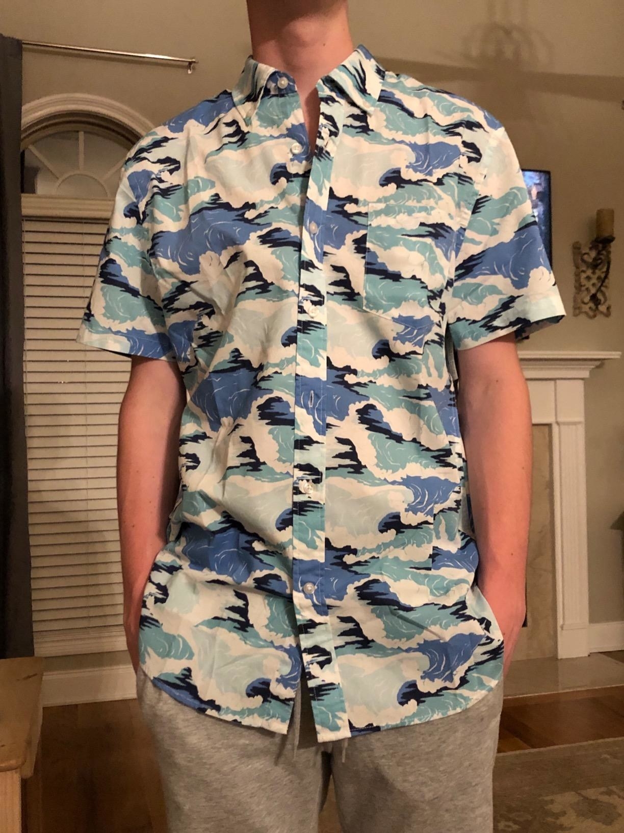 A reviewer wears the shirt with a wave pattern on it