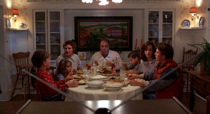 a family eats meatloaf at the dinner table