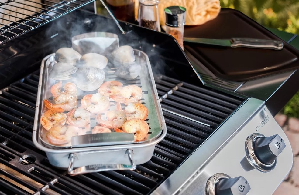 Shrimp and clams cooking in pan on top of grill 