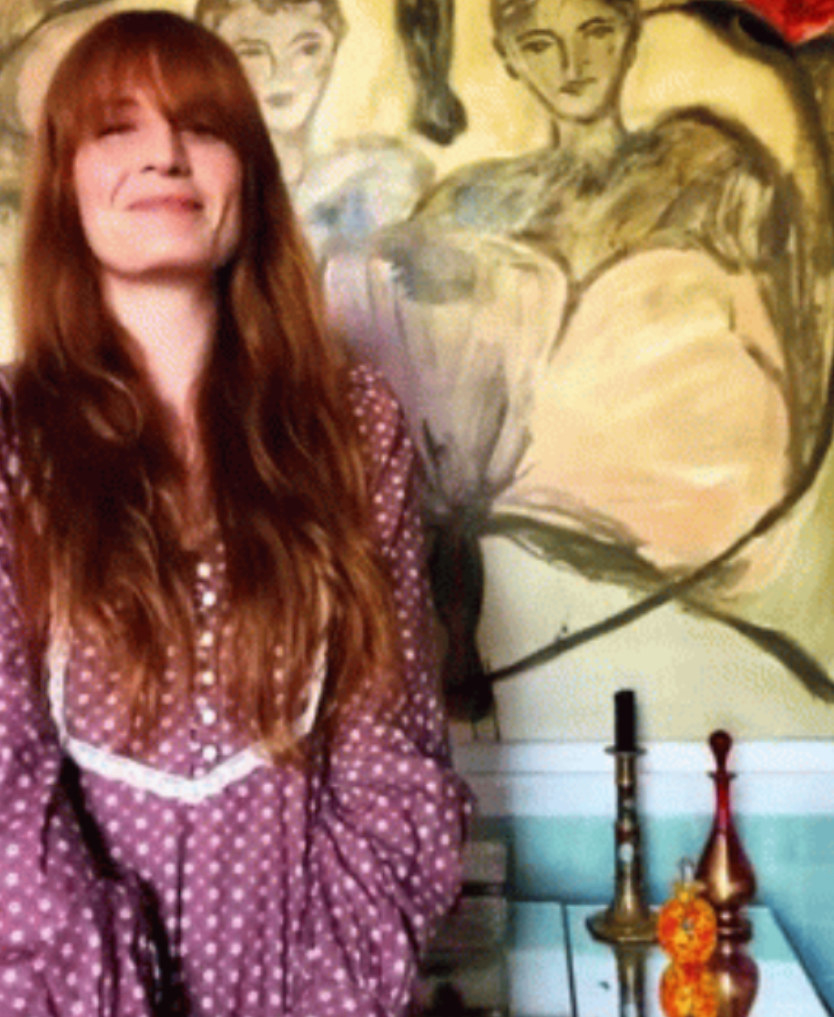 Florence Welch smiling while listening to music in her home