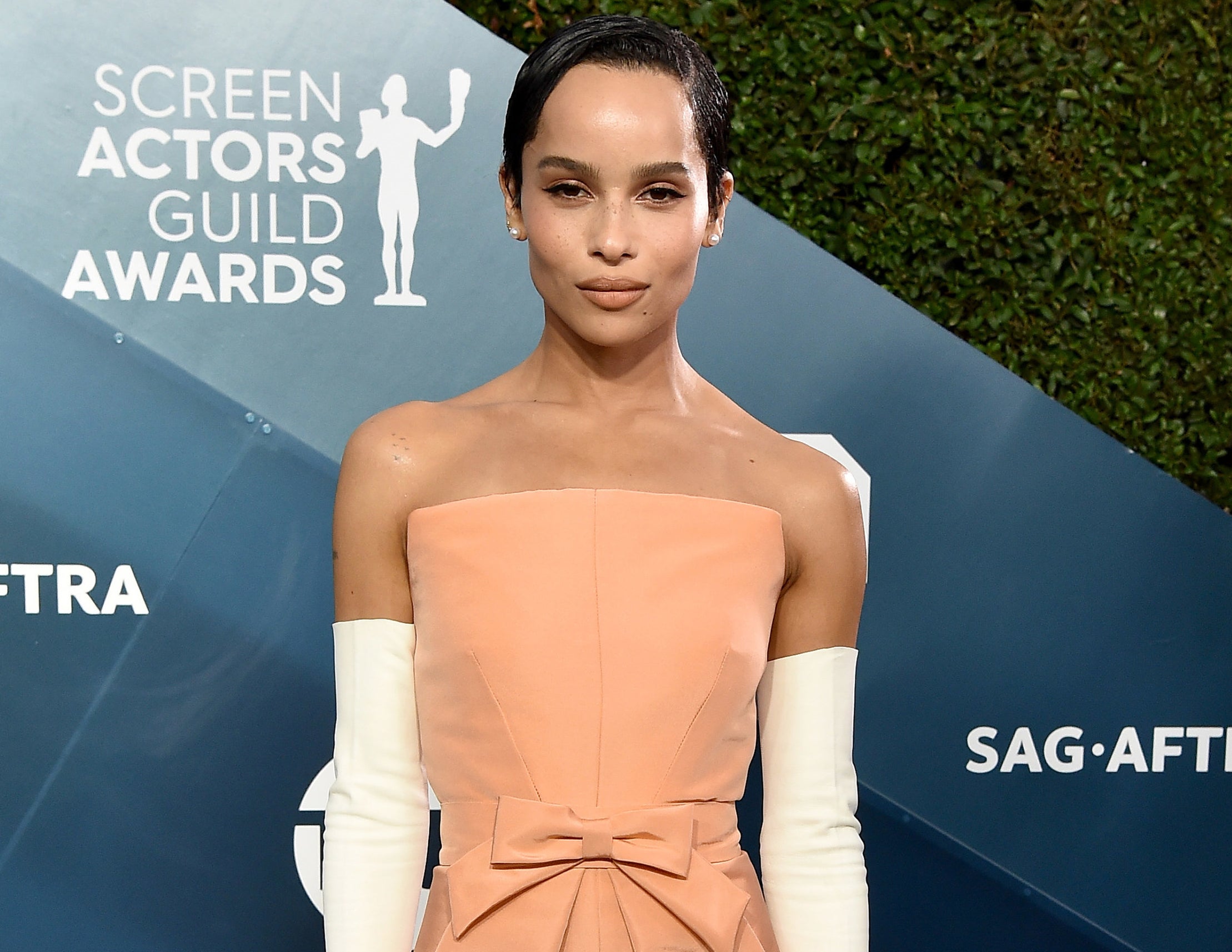 Zoe wears a strapless blush dress with white gloves to an event