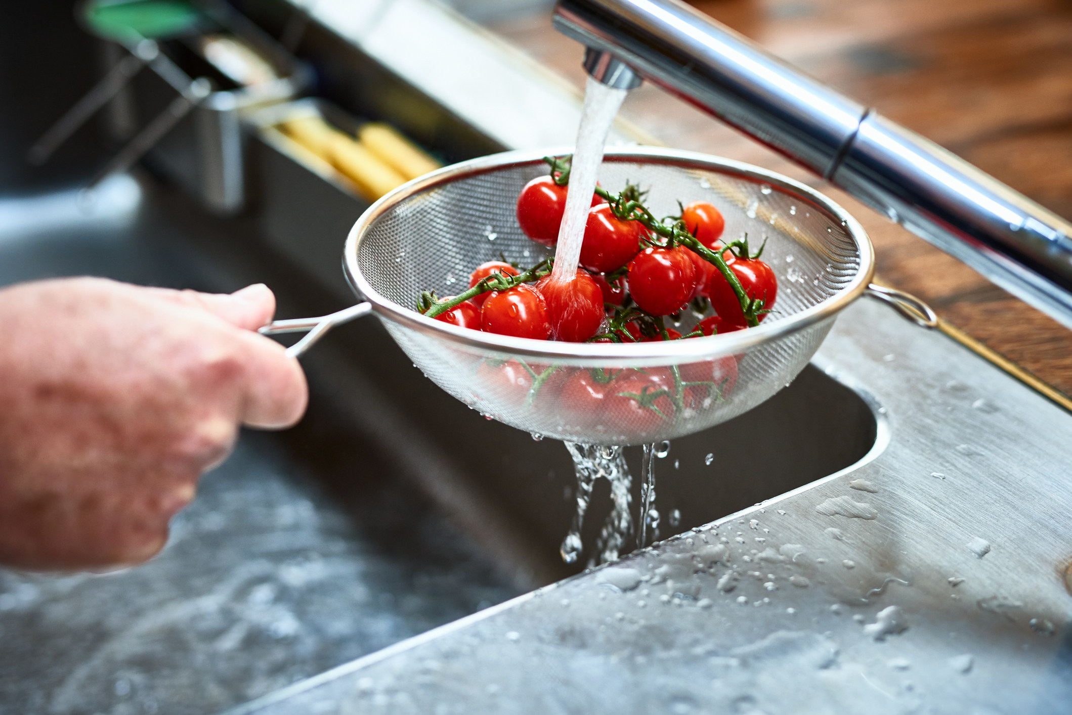 Washing tomatoes in sink 