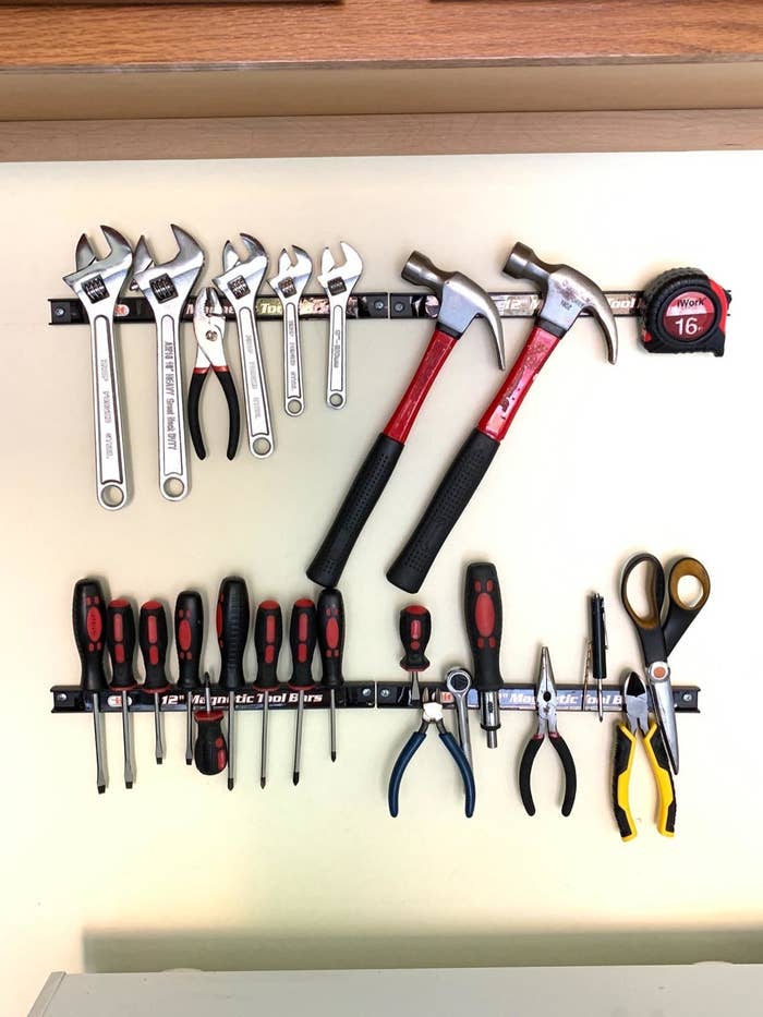 the bars on a reviewer&#x27;s garage wall, with wrenches, pliers, hammers, screwdrivers, and more attached to them