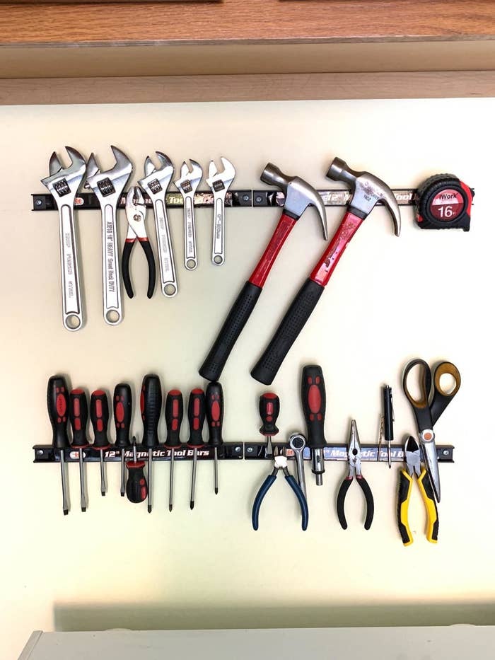 the bars on a reviewer's garage wall, with wrenches, pliers, hammers, screwdrivers, and more attached to them