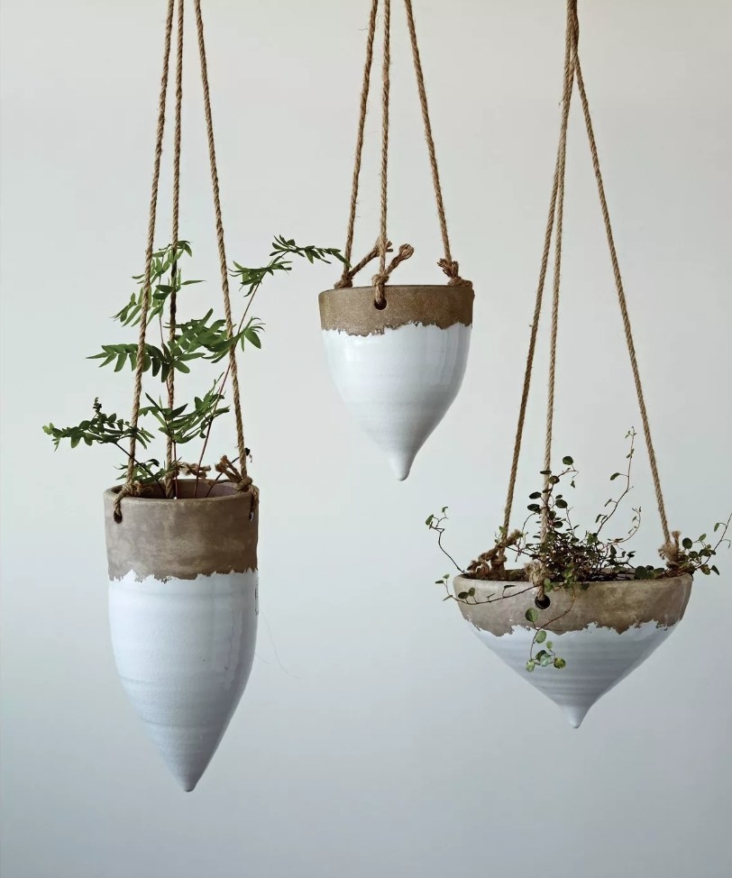 Brown and white cone shaped planters with jute rope and plants inside 