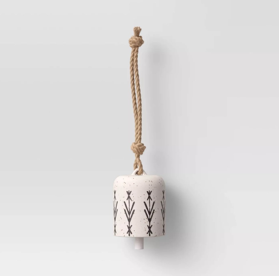 Beige ceramic wind chime with brown geometric design, hanging from brown rope 