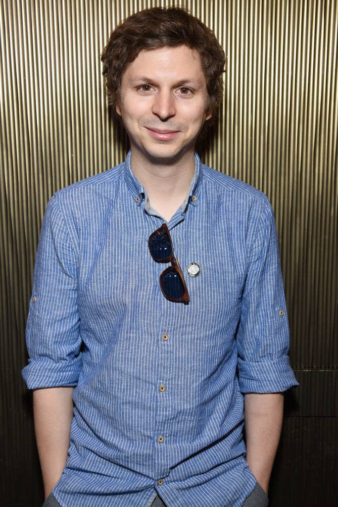 Michael Cera smiling with his hands in his pockets