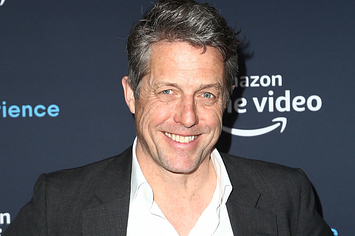 Hugh smiles while attending an event
