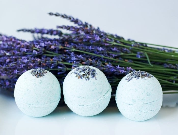 three bath bombs sitting in front of a bundle of eucalyptus 
