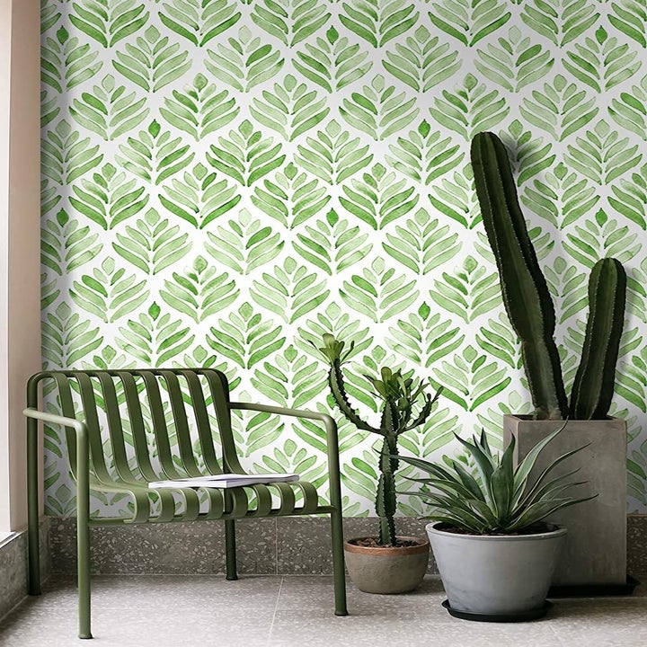 The leaf-patterned wallpaper on a wall behind a chair