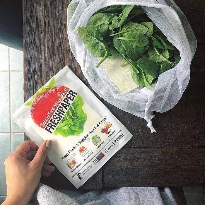 A bag of spinach with one of the sheets peeking out of it