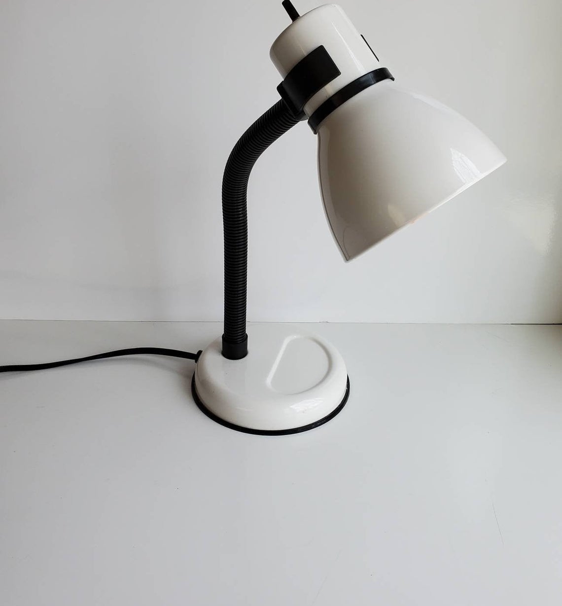 A white gooseneck desk lamp
