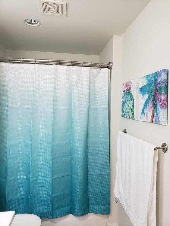 An ombre shower curtain set inside a reviewer&#x27;s bathroom