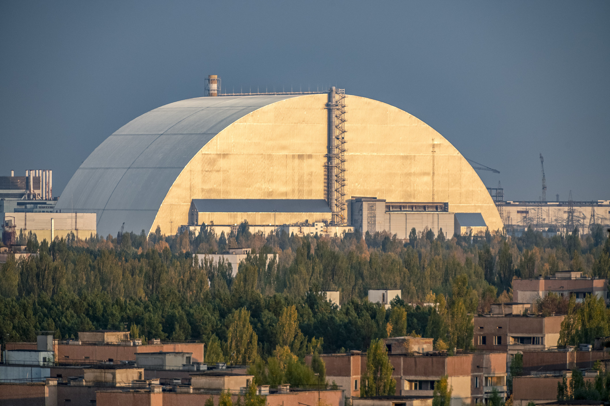 A large dome-like structure looming large in a semi-industrial and semi-residential landscape