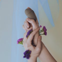 Model holding gray minimalist clitoral vibrator