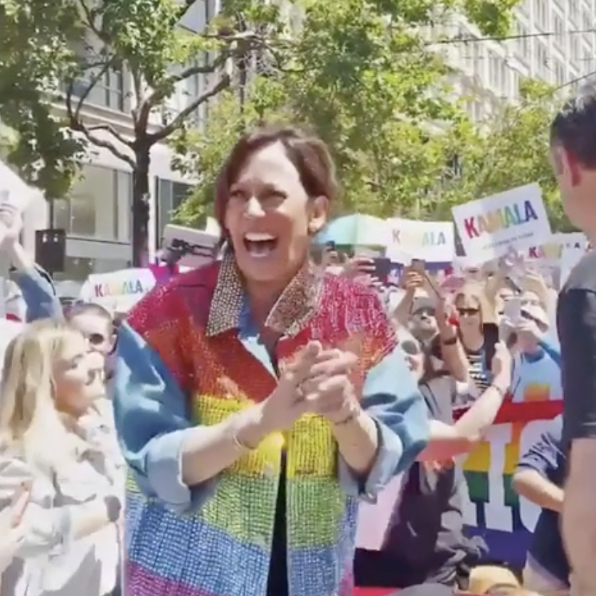 Kamala Harris happily dancing in a rainbow jacket at a Pride event