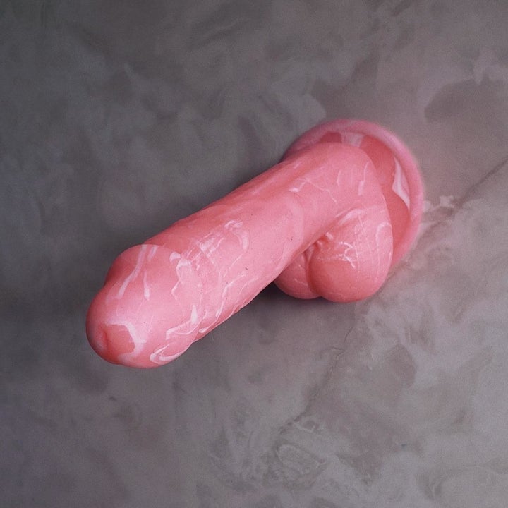 Pink marbled dildo attached to wall