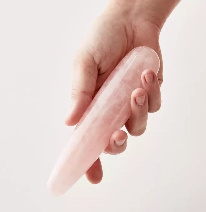 Model holding rose quartz cone-shaped dildo