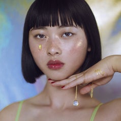 Model holding gemstone necklace