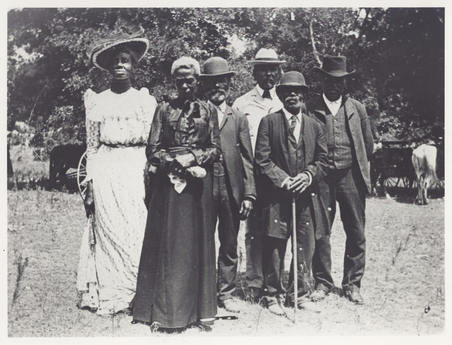 A group of people in elegant clothes from the 19th century pose for a portrait