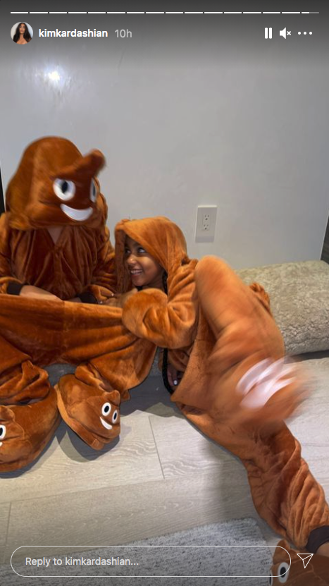 North West laughs while wearing a poop emoji onesie