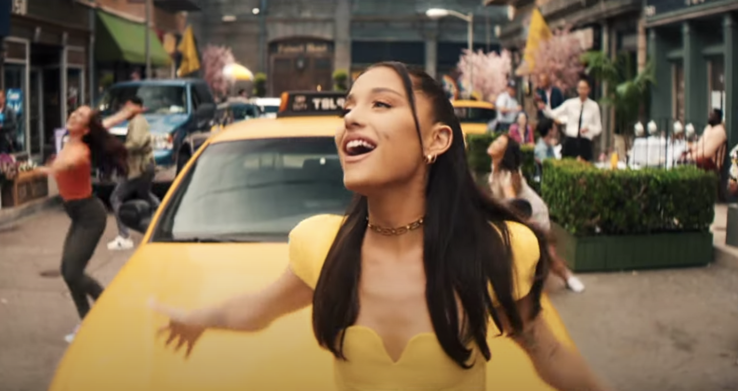 Ariana Grande smiling in a yellow dress