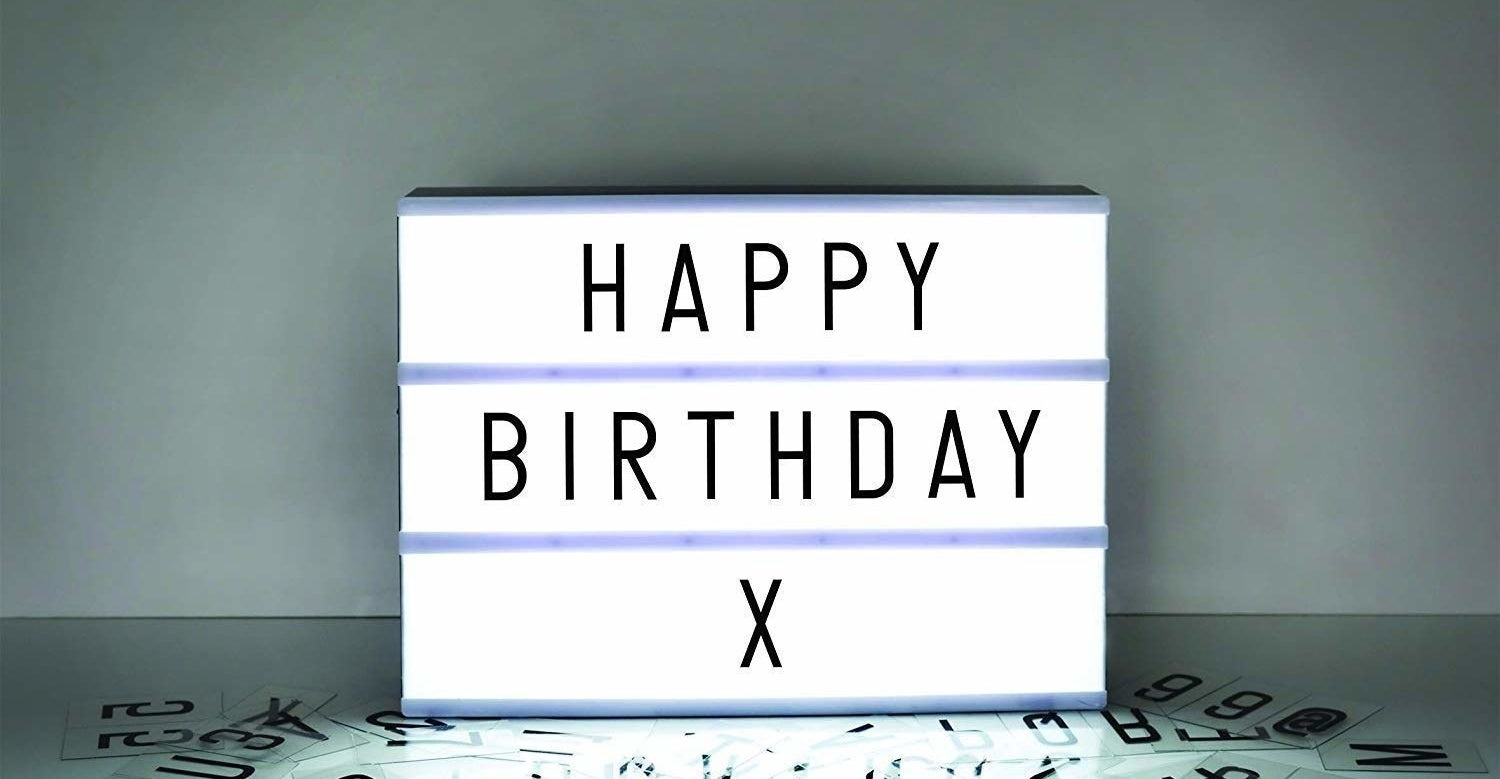 A cinema lightbox that says &quot;Happy Birthday X&quot;, with multiple letters and symbols strewn near it.
