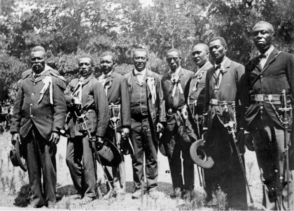 A group of men in cavalry gear standing as a group in a field