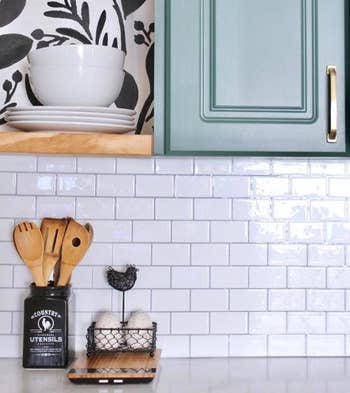 the removable tile in white along a kitchen wall under wall cabinets