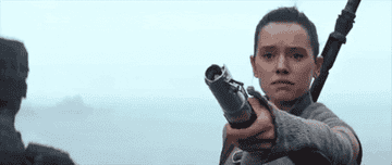 Rey holding out a lightsaber