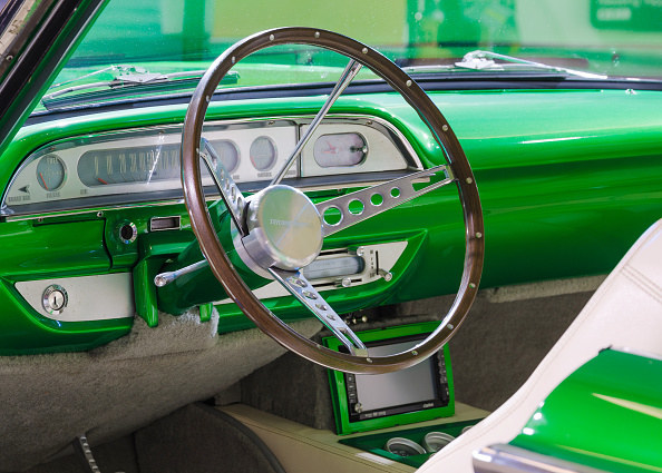 neon vintage car with metal dashboard and thin wheel